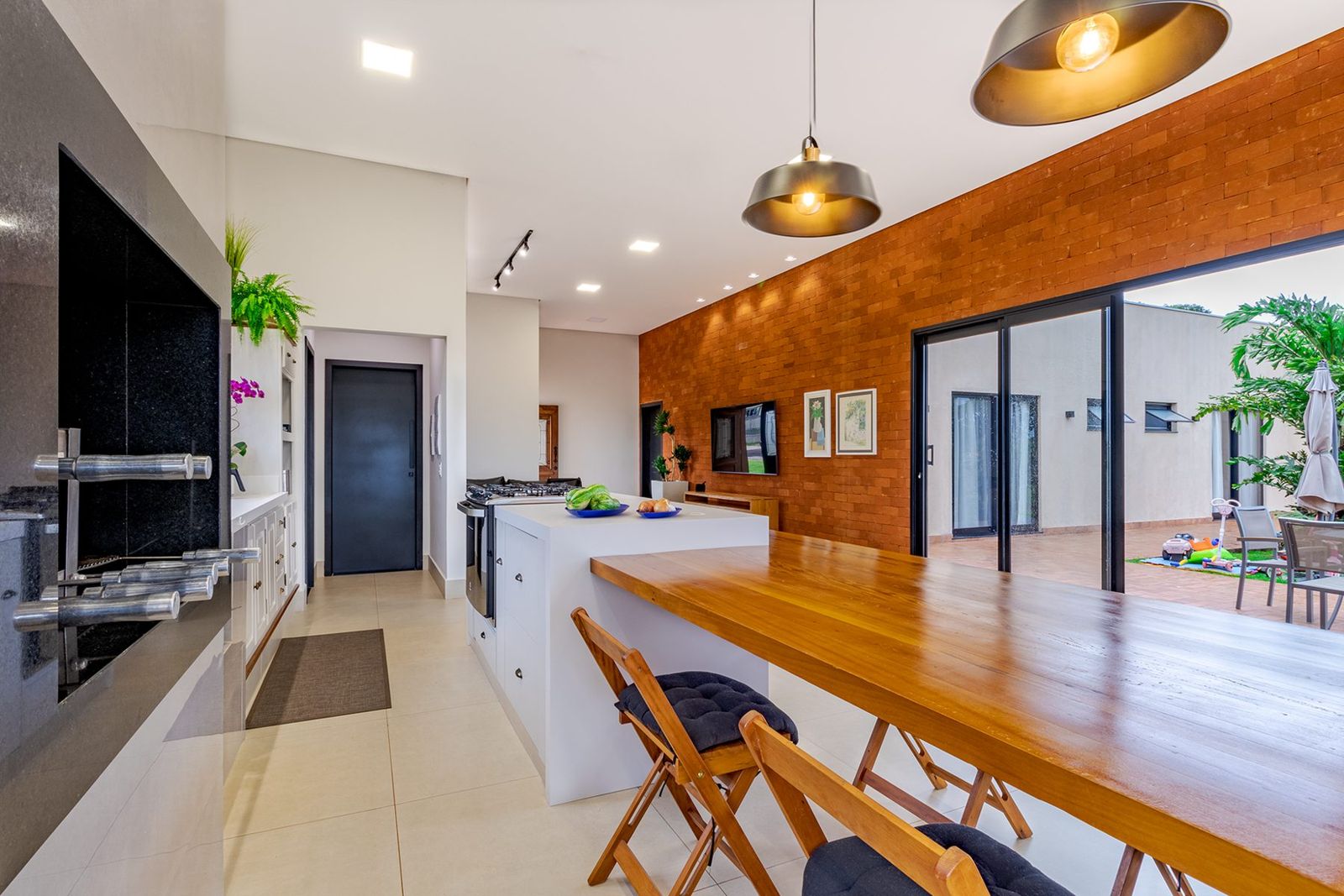 Cozinha integrada com parede de tijolos, Residência J&B