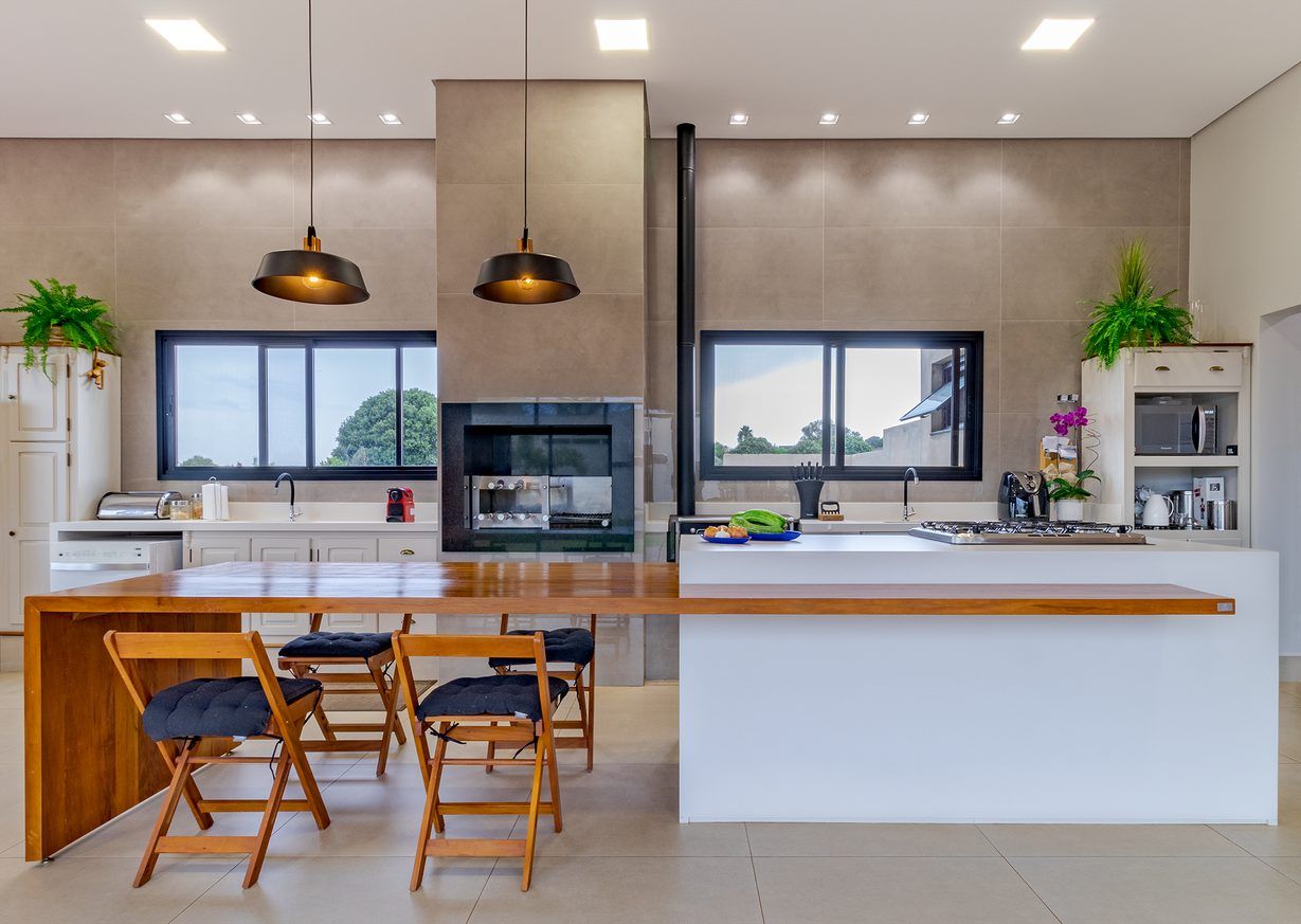 Cozinha com ilha e mesa em madeira